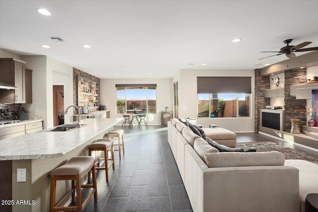 living room with ceiling fan and sink