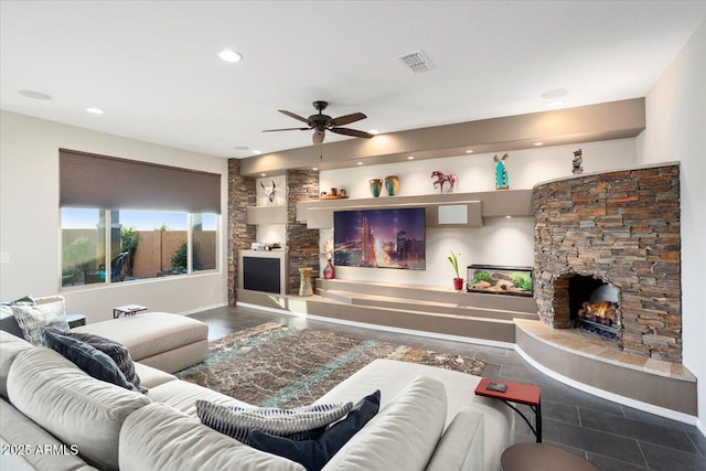 living room with tile patterned flooring, a stone fireplace, and ceiling fan