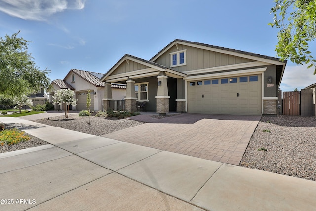 craftsman house with a porch, brick siding, fence, decorative driveway, and an attached garage