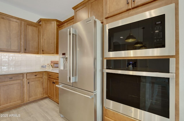 kitchen with appliances with stainless steel finishes, tasteful backsplash, and light countertops
