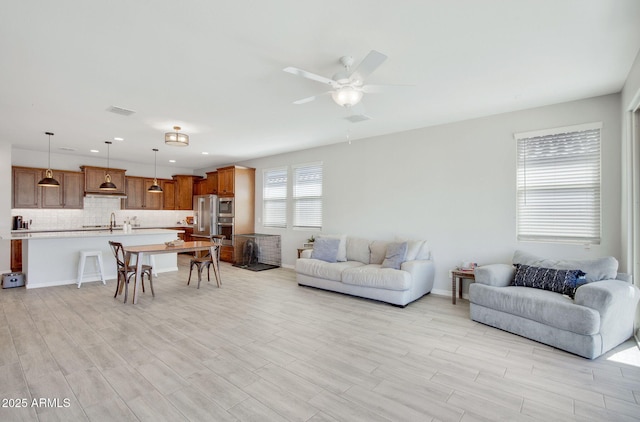 living room with visible vents, recessed lighting, ceiling fan, and light wood-style floors