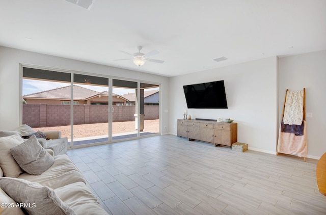 living area with visible vents, ceiling fan, light wood-style flooring, and baseboards