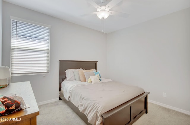 bedroom with baseboards, a ceiling fan, and light carpet