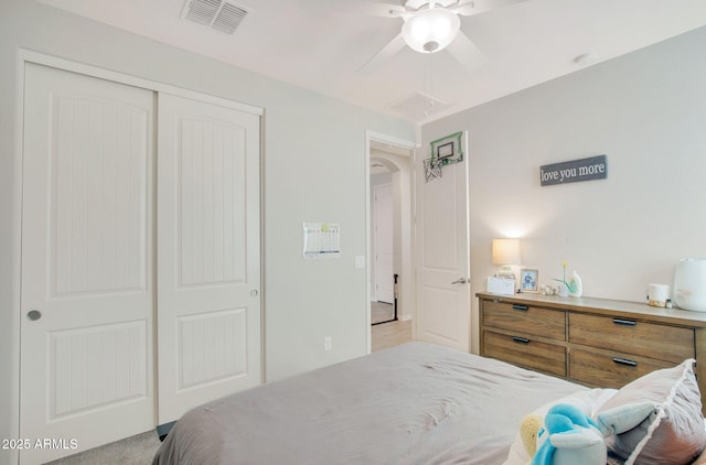 bedroom featuring visible vents, arched walkways, a ceiling fan, and a closet