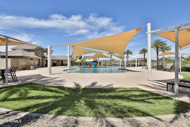 community pool with a yard, a patio area, and fence