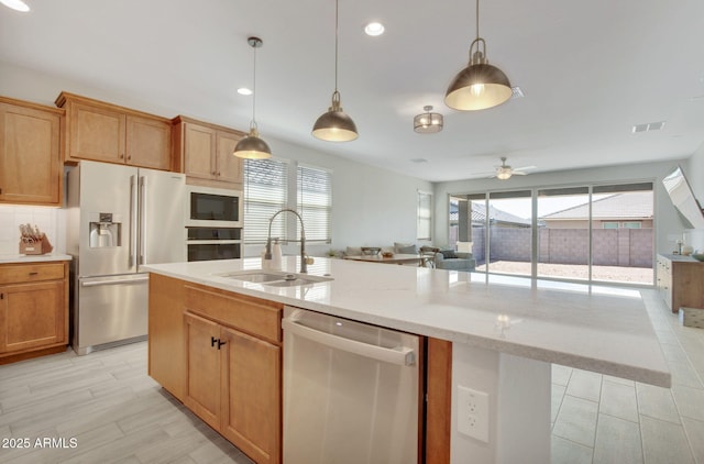 kitchen featuring a sink, ceiling fan, a wealth of natural light, appliances with stainless steel finishes, and open floor plan