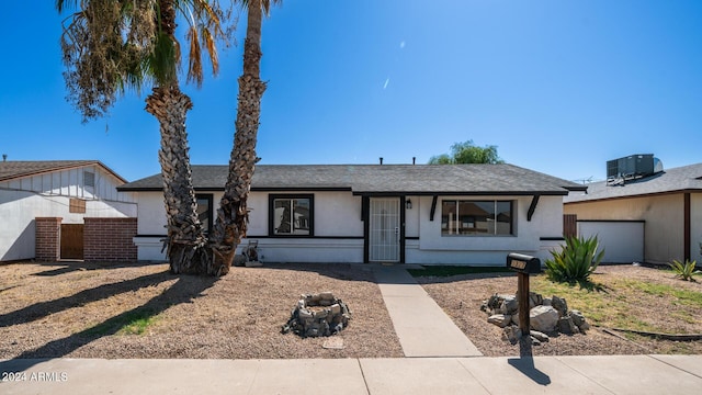 ranch-style home with a garage, central AC unit, and stucco siding