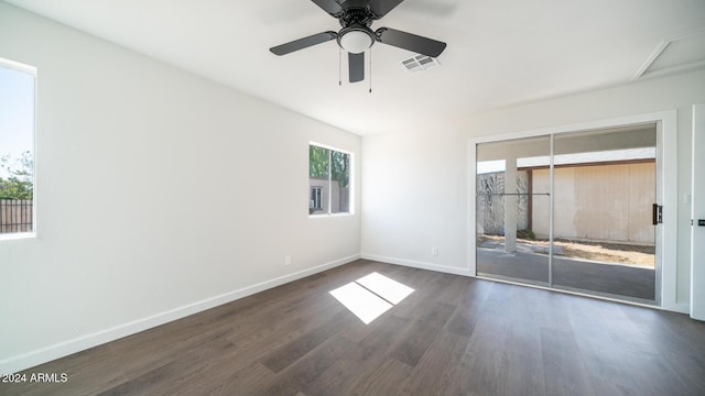 interior space with dark wood-type flooring, visible vents, baseboards, and a ceiling fan