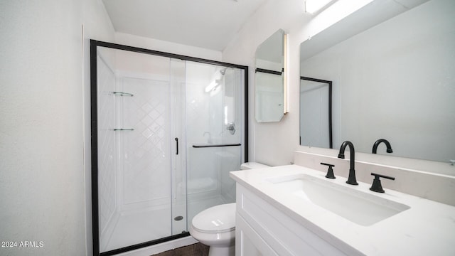 bathroom featuring toilet, a stall shower, and vanity