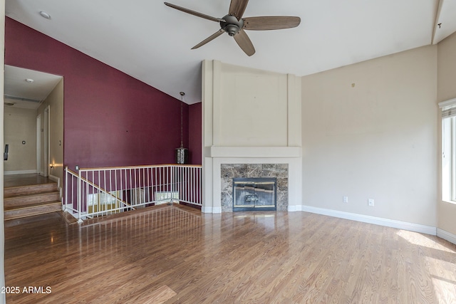 533 N Cobblestone St, Gilbert, AZ 85234 - unfurnished living room featuring vaulted ceiling, wood finished floors, ceiling fan, a high end fireplace, and baseboards