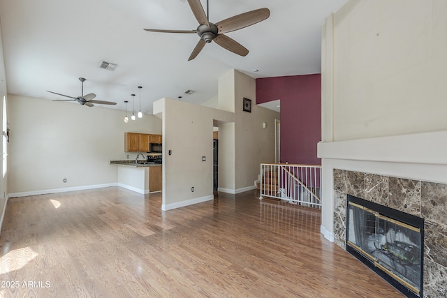 533 N Cobblestone St, Gilbert, AZ 85234 - unfurnished living room with ceiling fan, light wood-style floors, baseboards, and high vaulted ceiling