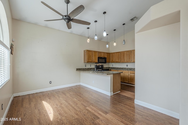 533 N Cobblestone St, Gilbert, AZ 85234 - kitchen featuring black appliances, wood finished floors, brown cabinetry, a peninsula, and ceiling fan
