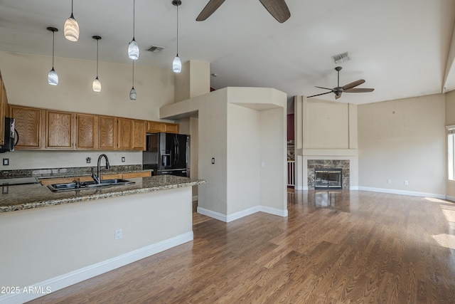 533 N Cobblestone St, Gilbert, AZ 85234 - kitchen featuring a ceiling fan, black fridge, brown cabinetry, pendant lighting, and wood finished floors