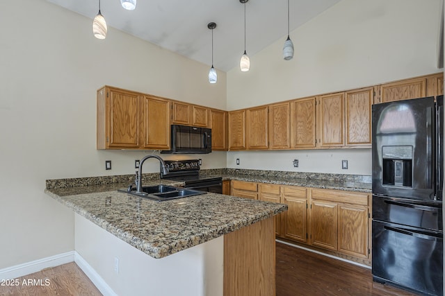 533 N Cobblestone St, Gilbert, AZ 85234 - kitchen featuring black appliances, a sink, a peninsula, dark wood-style flooring, and hanging light fixtures