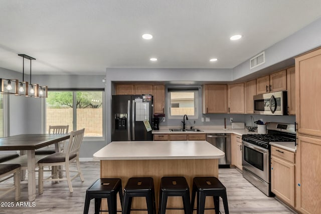 2934 S Woodruff Cir, Mesa, AZ 85212 - kitchen featuring stainless steel appliances, a breakfast bar, light wood-style floors, light countertops, and recessed lighting