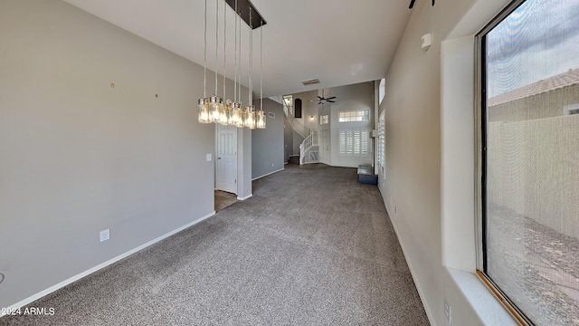 interior space with carpet flooring and ceiling fan