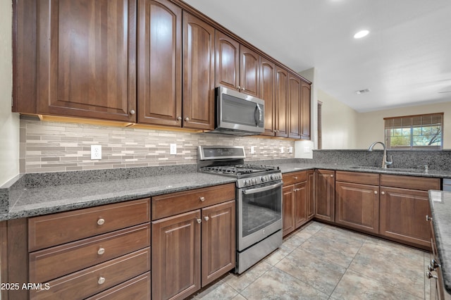 17429 W Red Bird Rd, Surprise, AZ 85387 - kitchen featuring backsplash, stainless steel appliances, stone counters, and a sink