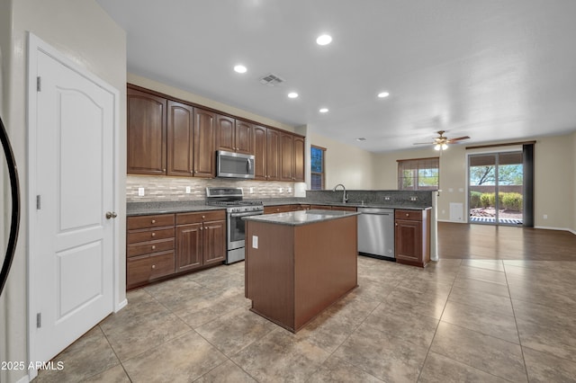 17429 W Red Bird Rd, Surprise, AZ 85387 - kitchen with ceiling fan, a center island, tasteful backsplash, a sink, and stainless steel appliances