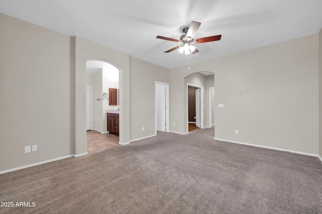 17429 W Red Bird Rd, Surprise, AZ 85387 - empty room featuring arched walkways, ceiling fan, carpet, and baseboards