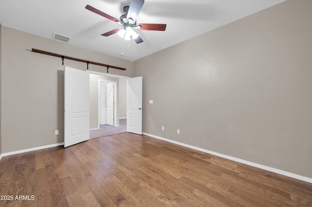 17429 W Red Bird Rd, Surprise, AZ 85387 - unfurnished bedroom featuring visible vents, baseboards, ceiling fan, and wood finished floors