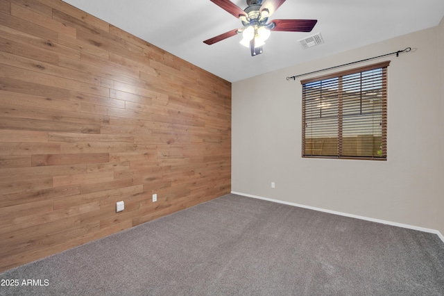 17429 W Red Bird Rd, Surprise, AZ 85387 - spare room featuring visible vents, carpet floors, wood walls, baseboards, and a ceiling fan