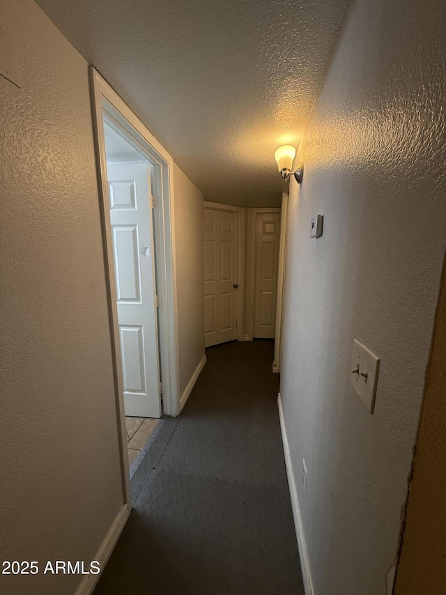 4231 N 69th Dr Unit 1297, Phoenix, AZ 85033 - hallway featuring carpet floors, a textured ceiling, and baseboards