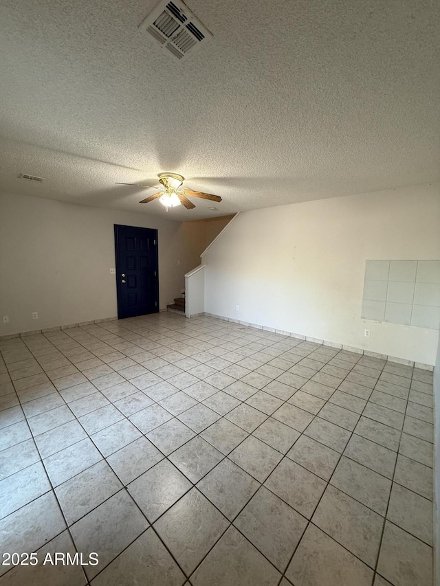 4231 N 69th Dr Unit 1297, Phoenix, AZ 85033 - empty room with a ceiling fan, a textured ceiling, and light tile patterned floors