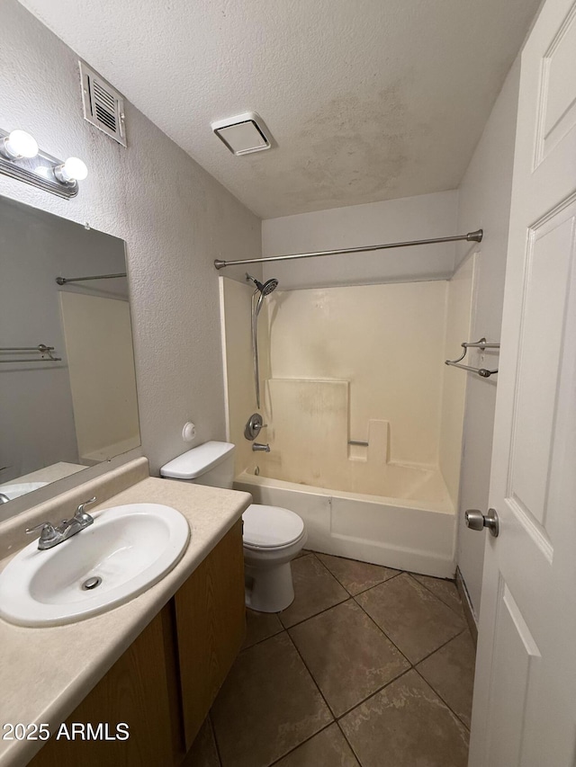 4231 N 69th Dr Unit 1297, Phoenix, AZ 85033 - bathroom featuring a textured ceiling, a textured wall, vanity, toilet, and tile patterned floors