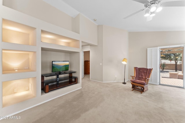 sitting room featuring visible vents, a ceiling fan, carpet, built in shelves, and high vaulted ceiling