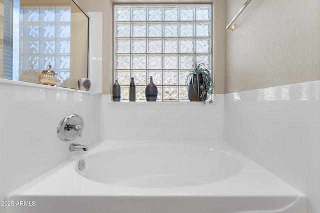bathroom featuring a healthy amount of sunlight and a garden tub