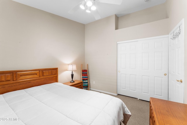 carpeted bedroom featuring ceiling fan, a closet, and baseboards
