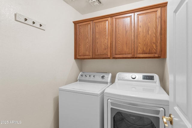 washroom with cabinet space, visible vents, and washing machine and clothes dryer