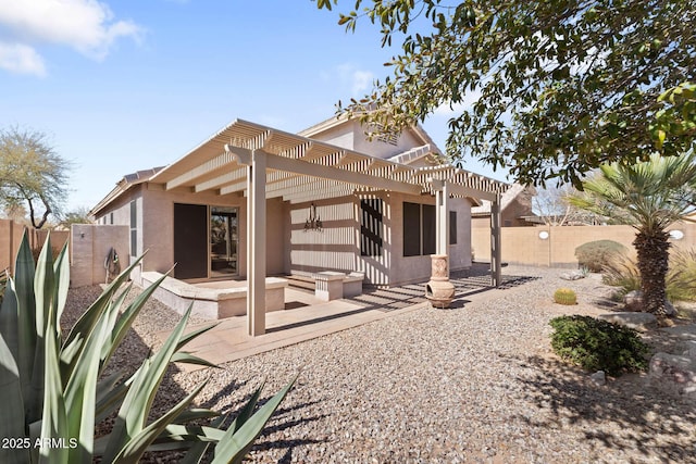 back of property with a pergola, stucco siding, a patio, and fence