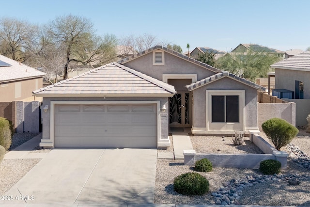 view of front facade featuring driveway, a tiled roof, an attached garage, and stucco siding