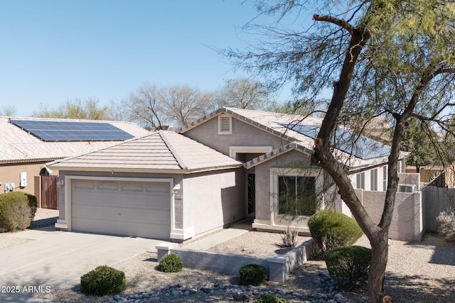 view of front of house featuring stucco siding, a tile roof, driveway, and fence