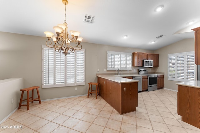 kitchen with a peninsula, appliances with stainless steel finishes, a sink, and visible vents