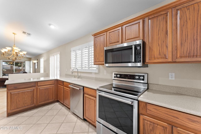 kitchen with stainless steel appliances, light countertops, brown cabinets, and a sink
