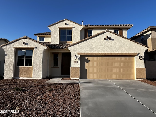 mediterranean / spanish-style house with stucco siding, a tiled roof, concrete driveway, and a garage