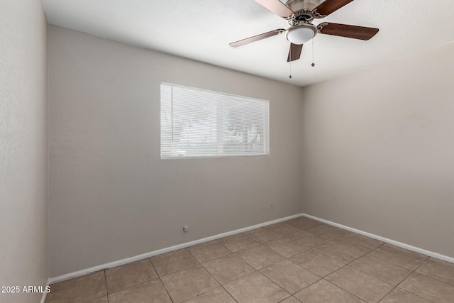 spare room with light tile patterned floors, a ceiling fan, and baseboards