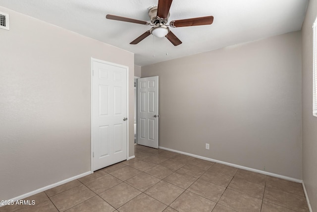 unfurnished room with light tile patterned floors, visible vents, baseboards, and ceiling fan