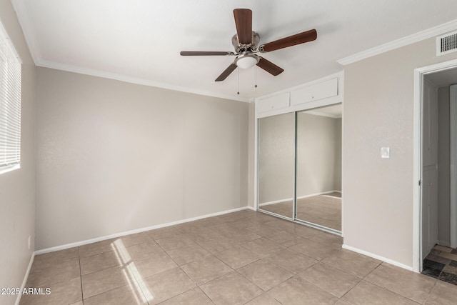 unfurnished bedroom featuring light tile patterned floors, baseboards, ceiling fan, a closet, and crown molding