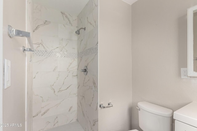 bathroom featuring a marble finish shower, toilet, and vanity