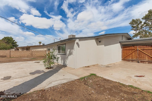 view of side of home with fence and a patio area