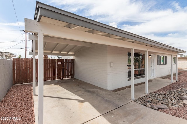 view of patio featuring a carport and fence