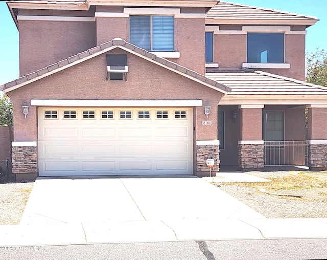 traditional-style house featuring an attached garage, a tile roof, and stone siding