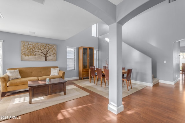 living room featuring an inviting chandelier, high vaulted ceiling, and light hardwood / wood-style flooring