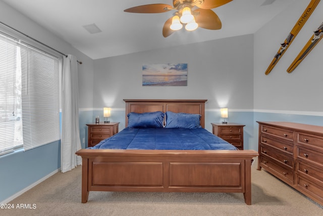 bedroom featuring lofted ceiling, light colored carpet, ceiling fan, and multiple windows