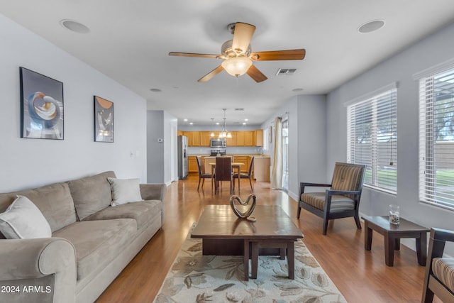 living room with light hardwood / wood-style floors and ceiling fan