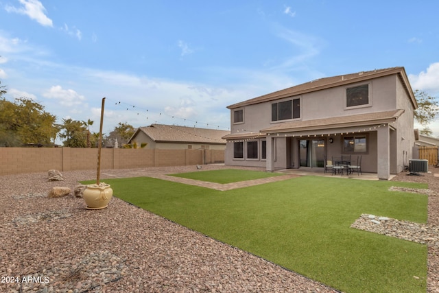 back of house with central AC unit, a yard, and a patio area