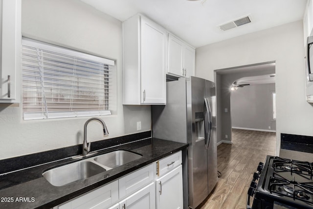 kitchen with white cabinetry, sink, and dark stone counters